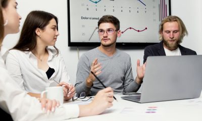 Antreprenor scriind conținut de marketing la un laptop, într-un birou mic de afaceri