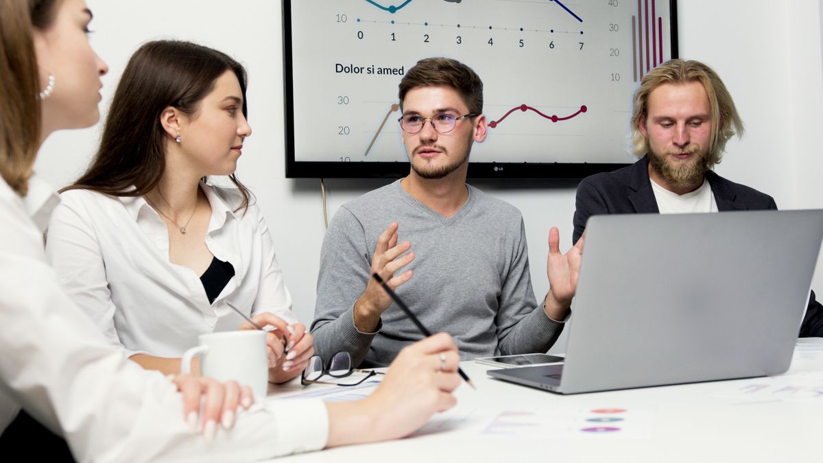 Antreprenor scriind conținut de marketing la un laptop, într-un birou mic de afaceri